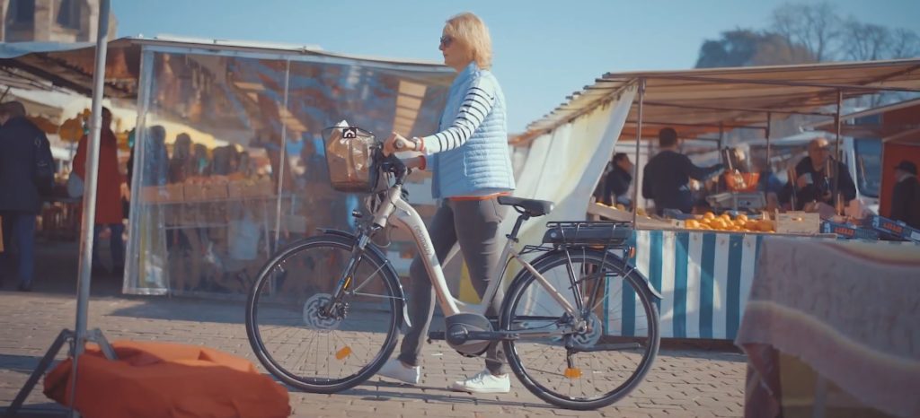 femme avce velo electrique au marché